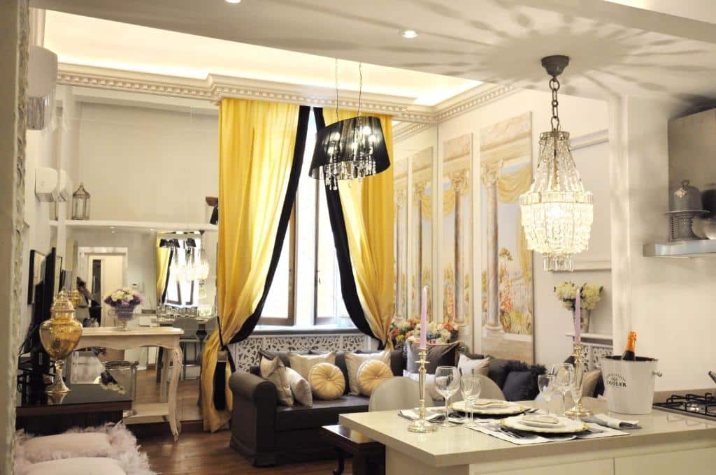 sala do The Right Place 4U Roma Savelli Boutique Apartment, uma das opções de onde ficar em Roma, muito decorada, com mesa e cadeiras, lustre moderno, sofá e cozinha