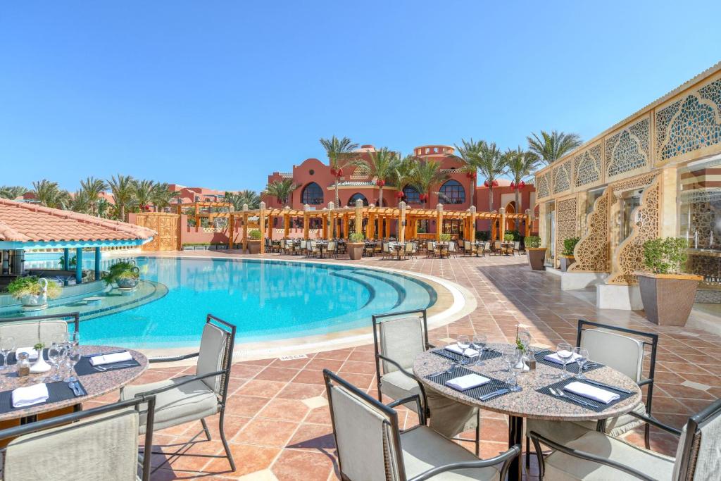 Vista da piscina do Magic World Sharm em Sharm el-Sheikh, com mesas e cadeiras e arquitetura de estilo árabe clássico