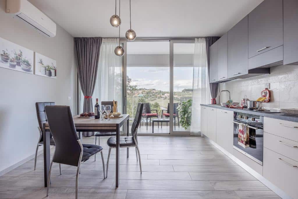 Cozinha moderna integrada com sala de jantar, vista para zona verde e decoração clean