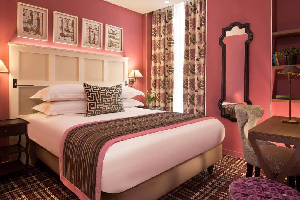 Quarto de paredes cor-de-rosa no Les Tournelles, um dos hotéis onde ficar em Paris