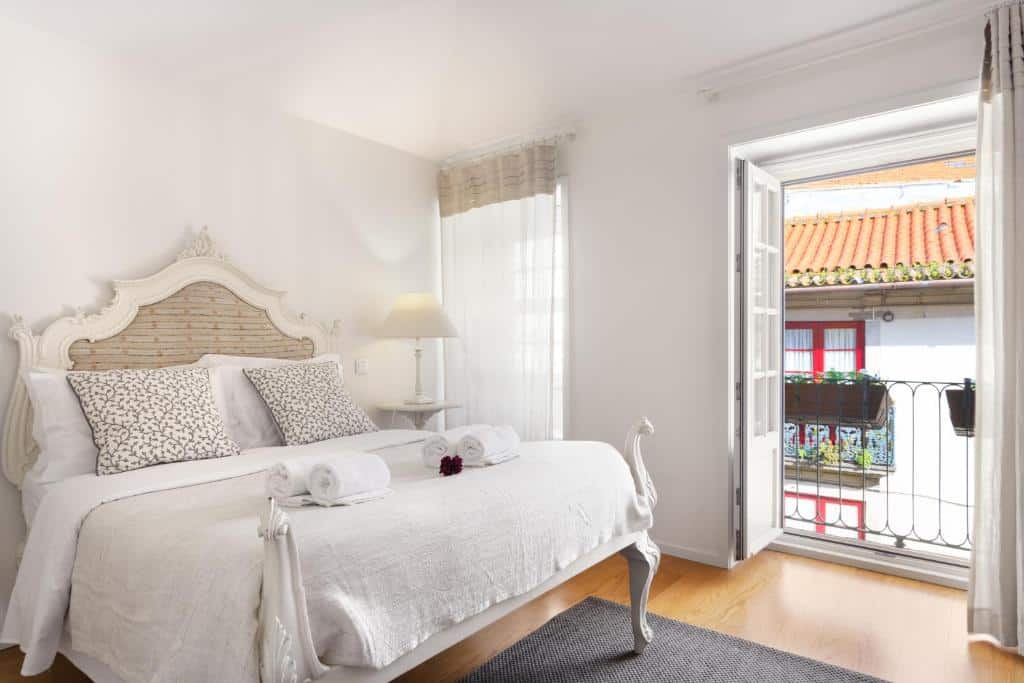 Quarto do Historical Center – Taipas Apartments, com cama de casal à esquerda e um candeeiro à direita.