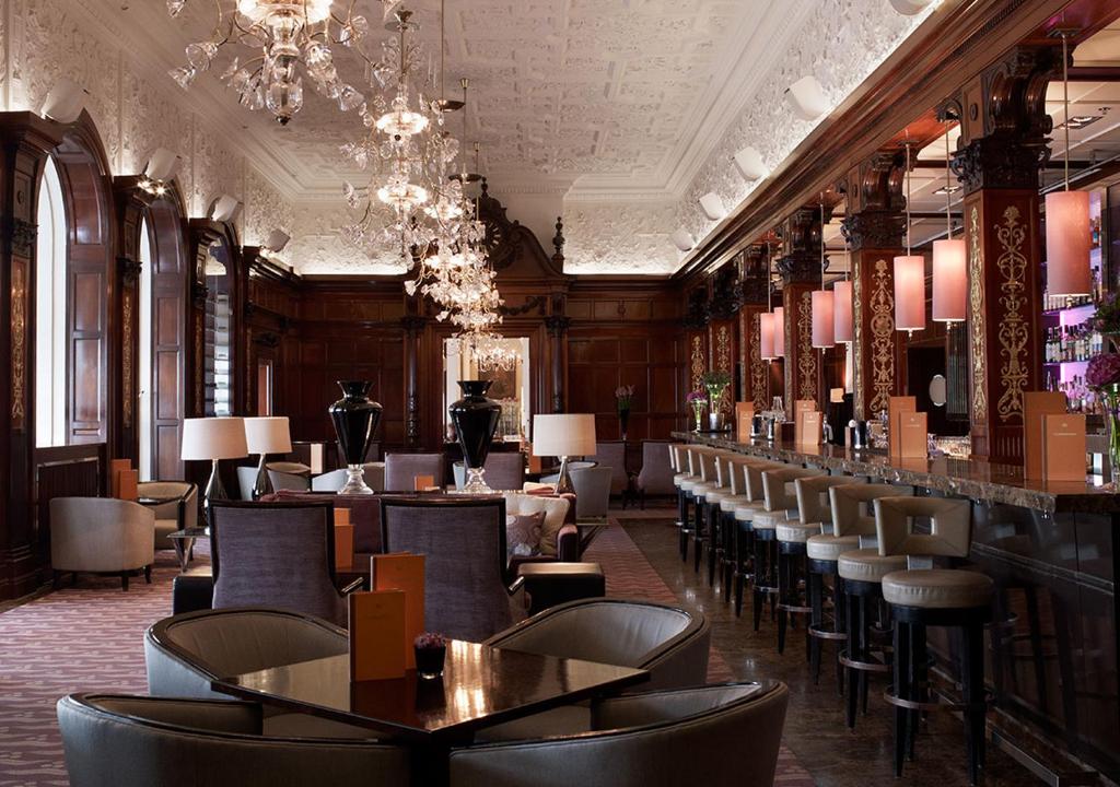 Sala de refeições do Grand Hôtel Stockholm com cadeiras, balcão e mesas.