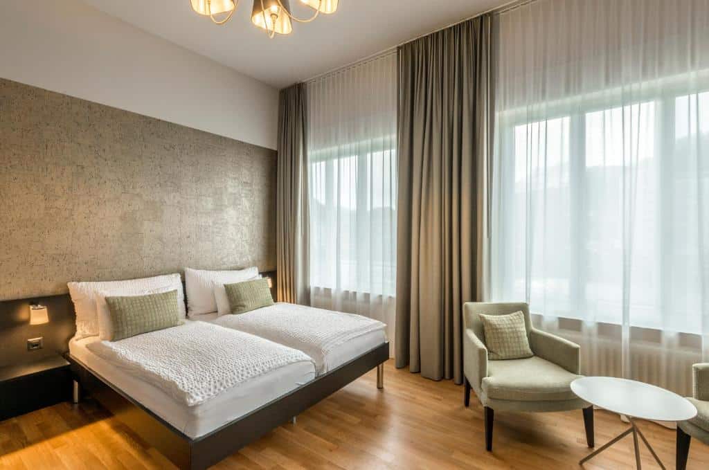 Quarto do Boutique Hotel KARL, em Lucerna, espaçoso, com cama de casal e mesa redonda.