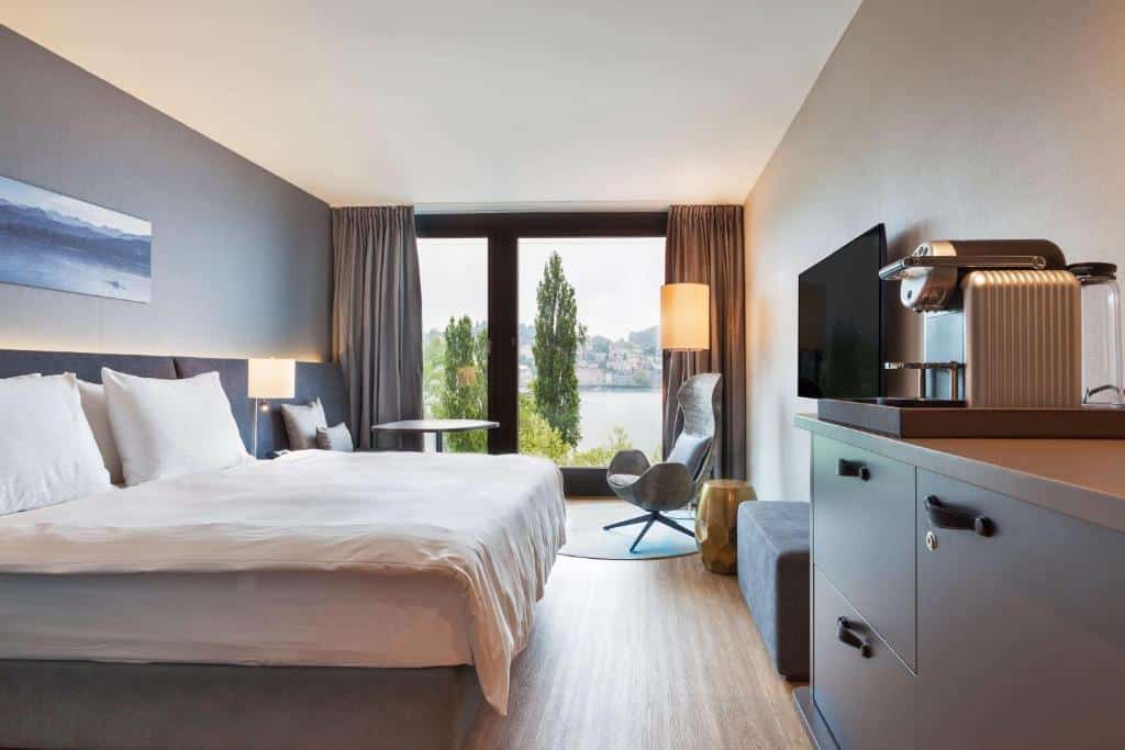 Quarto do Radisson Blu Hotel, em Lucerna, com cama de casal e grande janela com vista.