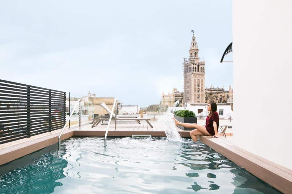 Piscina no terraço do Joya del Casco Boutique Hotel by Shiadu, com espreguiçadeiras e vista sobre a cidade.