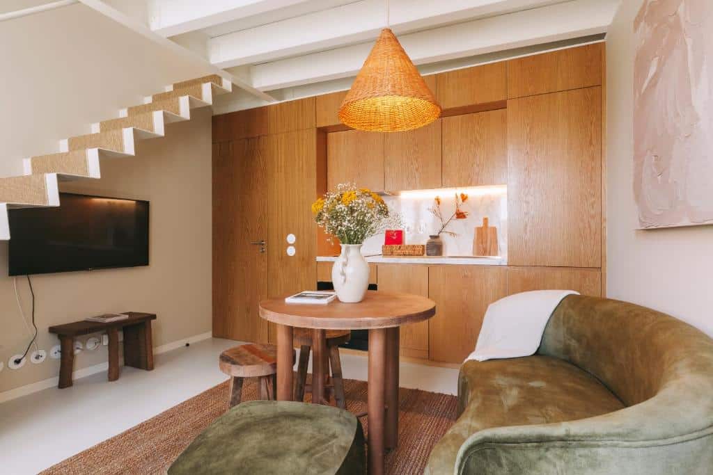 Sala do Village Aparthotel By BOA com sofá, mesa de centro e televisão em frente.