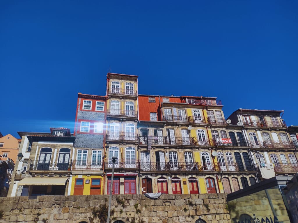 Casas coloridas no Cais da Ribeira durante o dia.