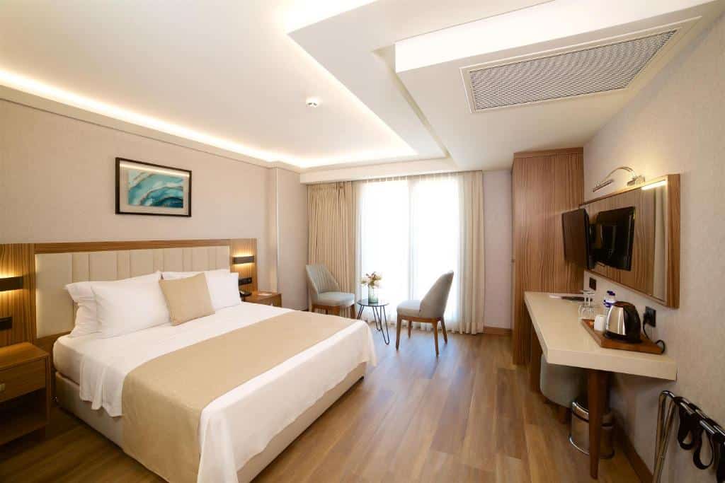 Quarto do Erboy Hotel Istanbul Sirkeci com uma cama de casal, secretária, cadeiras e uma grande janela com cortinados transparentes que deixam entrar luz natural.