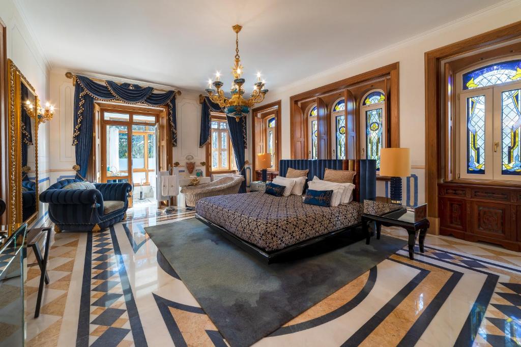 Quarto muito espaçoso do Sintra Marmoris Palace, com janelas de vitrais coloridos, cama de casal e banheira