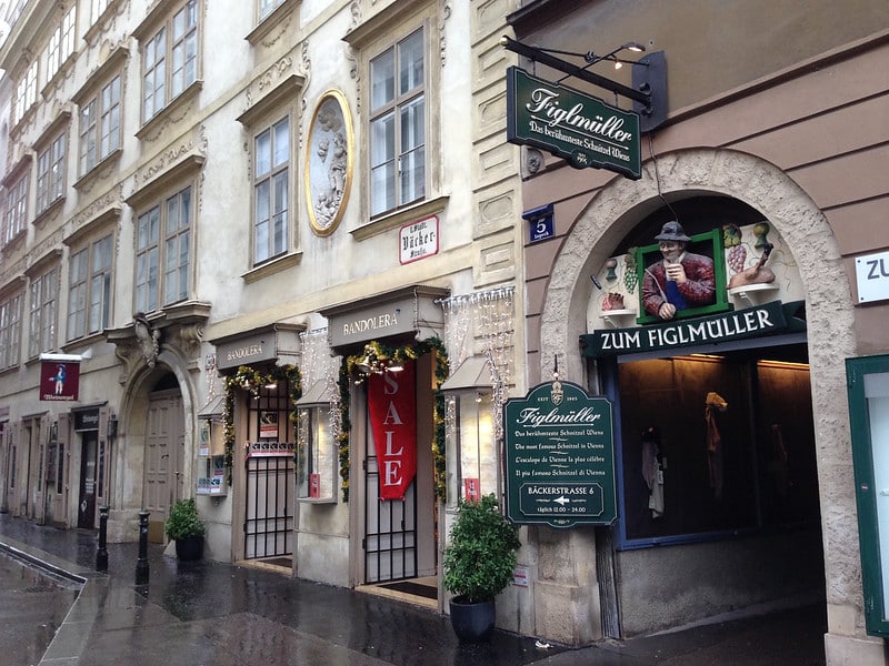 Cena de rua em Viena, com as duas entradas do restaurante Figlmüller bem visíveis.