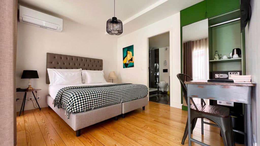 Quarto do Jardim da Lapa by Shiadu com cama de casal, ar condicionado de teto, secretária e espaço para preparar café