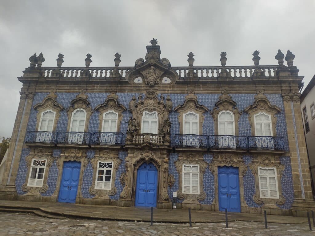 Vista diurna do Palácio do Raio, com fachada de azulejos e portas azuis.
