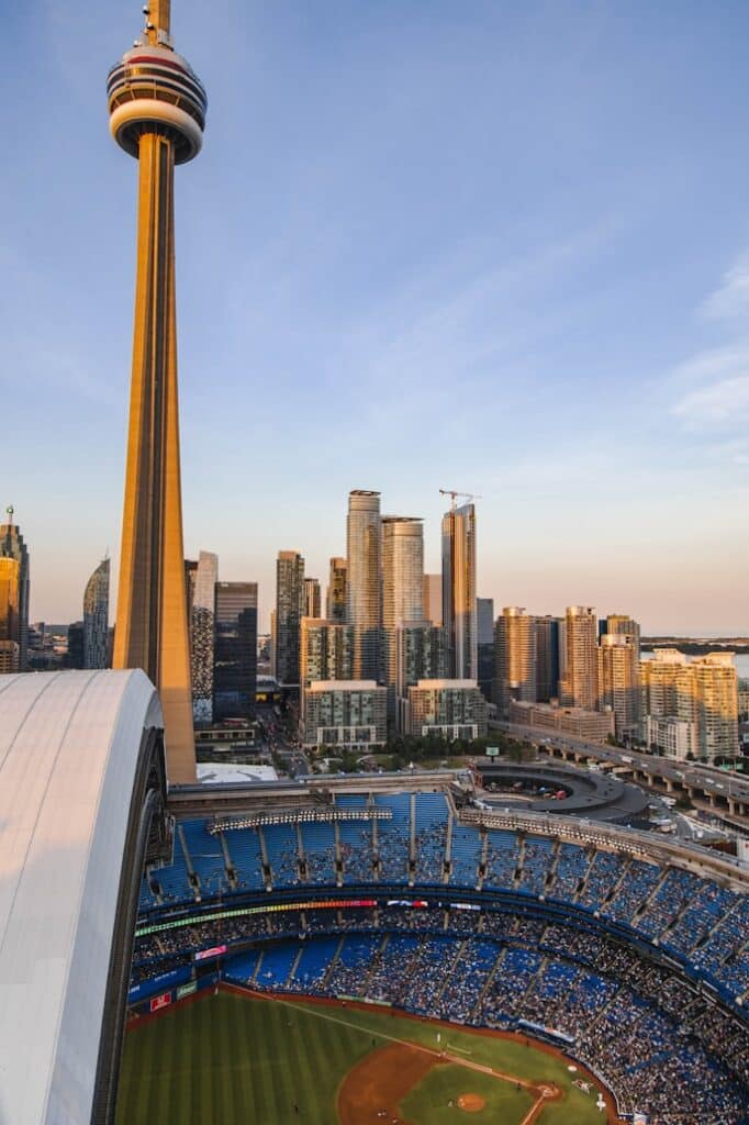 CN Tower e arranha-céus do centro de Toronto ao fundo, e parte da Scotiabank Arena com adeptos em primeiro plano