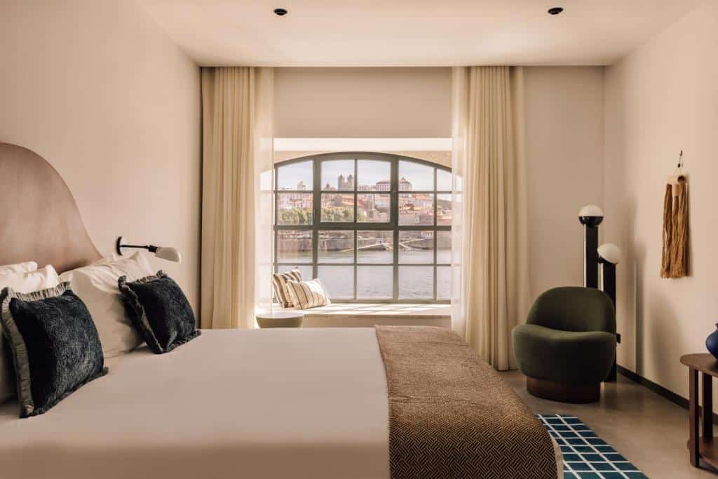 Quarto do The Rebello Hotel & Spa, com cama de casal e um cadeirão.