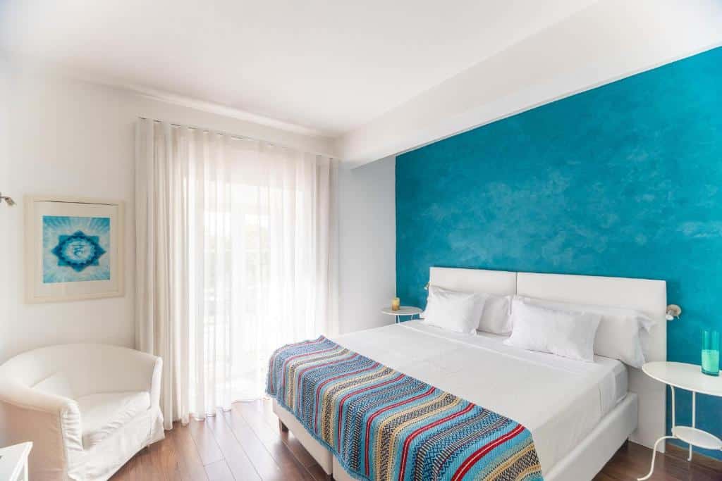 Quarto moderno com cama branca e parede azul-turquesa na Casa do Plátano, em Arraiolos