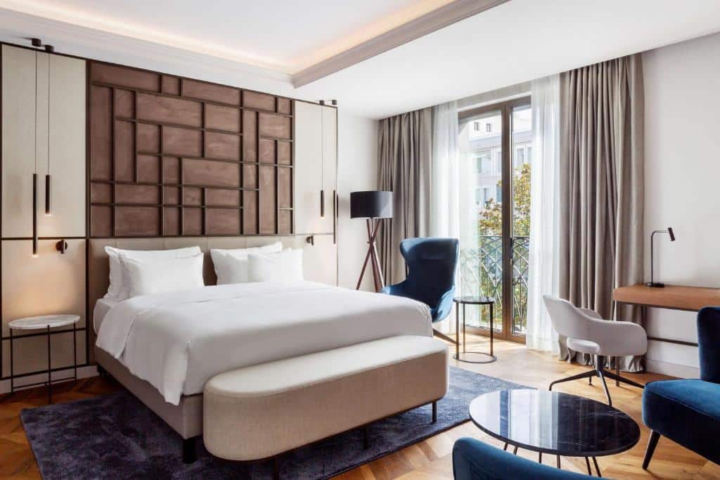 Quarto do Radisson Collection Hotel, Magdalena Plaza Sevilla, com cama de casal, secretária e poltrona junto à janela.