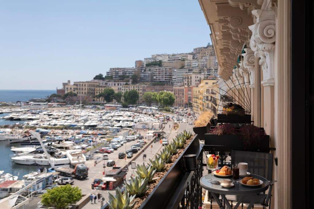 Edifícios de estilo clássico, barcos e iates atracados no porto, com decoração floral na varanda e vista panorâmica sobre a marginal, no Demetra Luxury Suites.