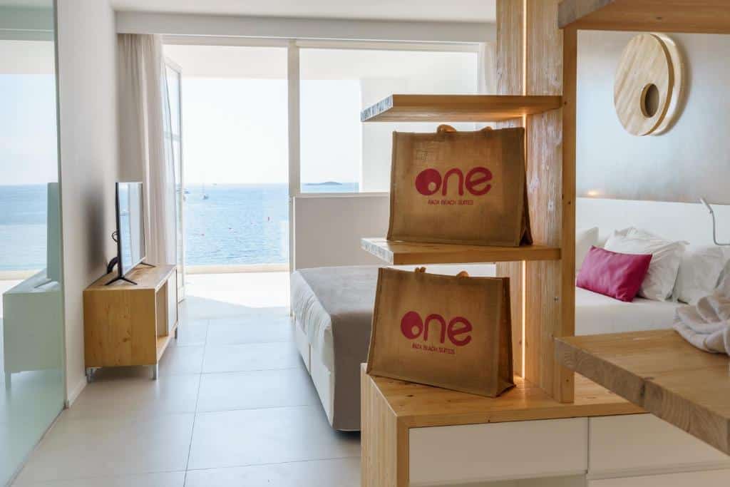 Quarto moderno do One Ibiza Suites com vista para o mar e mobiliário de madeira.