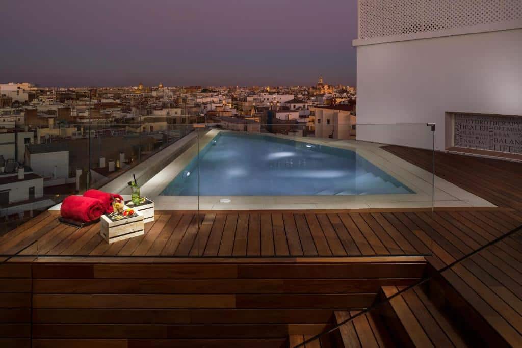 Piscina exterior do Hotel Colón Gran Meliá, rodeada de vidro com vista sobre a cidade.