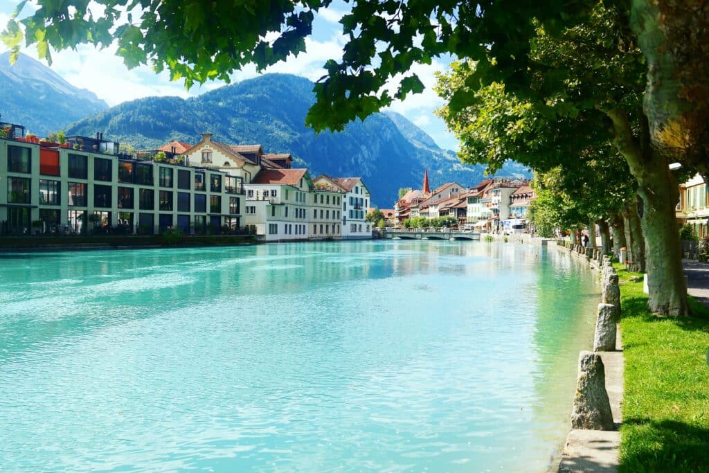 Rio a atravessar Interlaken durante o dia, com casas de estilo alpino nas margens.