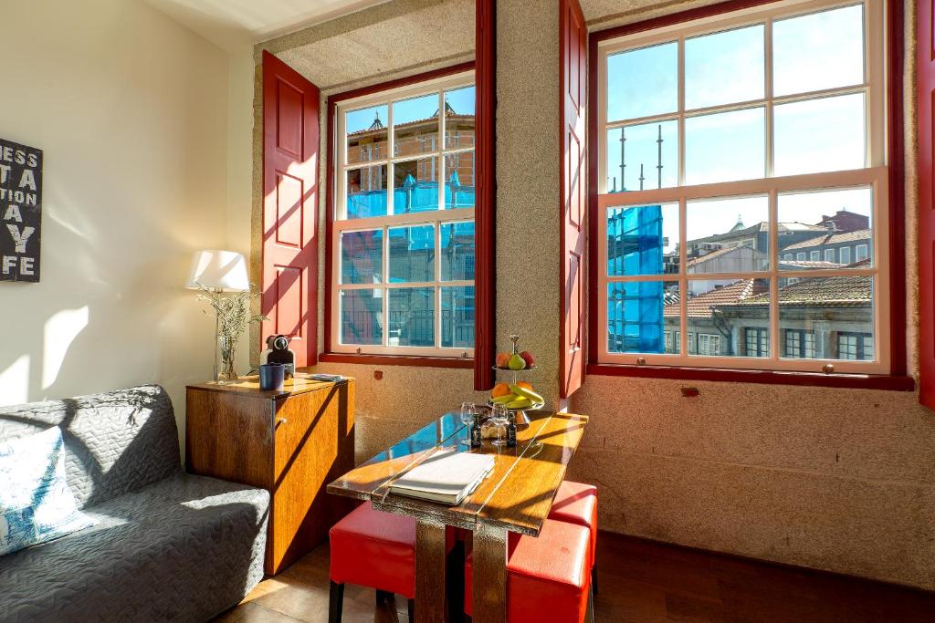 Sala do Flores Lofts, com mesa e bancos em primeiro plano e um sofá à esquerda.
