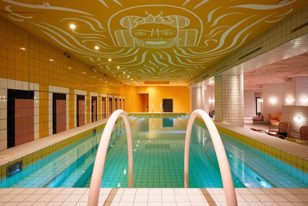 piscina interior do Mama Shelter Roma, uma das opções de onde ficar em Roma, com escadas e frescos dourados no teto