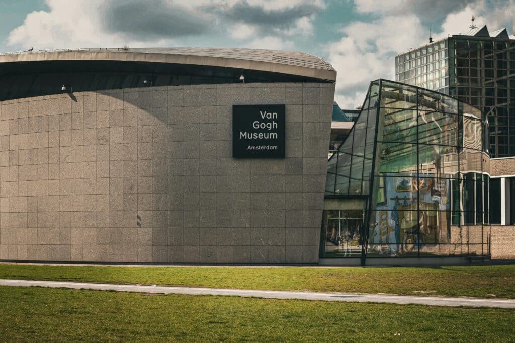 Exterior do Museu Van Gogh em Amesterdão, com arquitetura moderna e uma placa na parede de pedra.