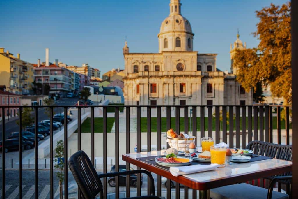 Varanda do Wine & Books Lisboa Hotel com mesa e duas cadeiras e itens de pequeno-almoço