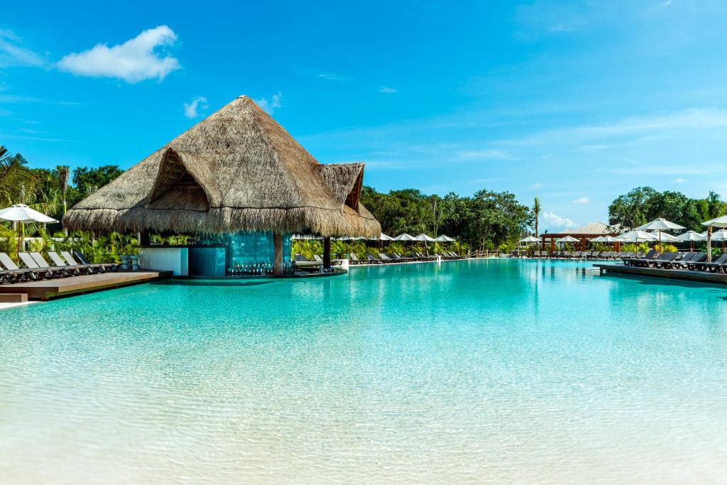 Grande piscina do Ocean Riviera Paradise com tudo incluído, com bar de palha e espreguiçadeiras.