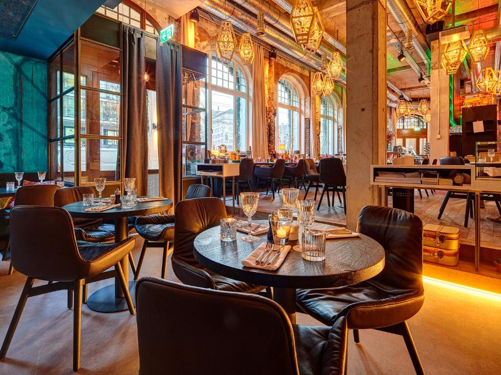 Restaurante sofisticado no Hotel Anker Luzern, com mesas de madeira escura e iluminação intimista.