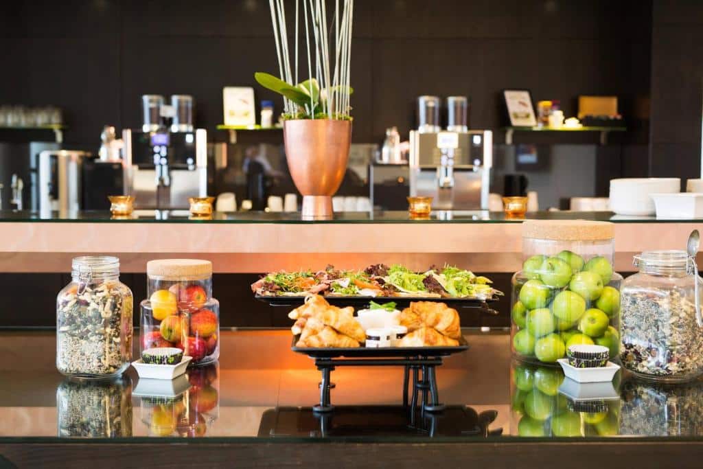 Mesa de pequeno-almoço do Courtyard by Marriott Stockholm Kungsholmen com fruta e pães.