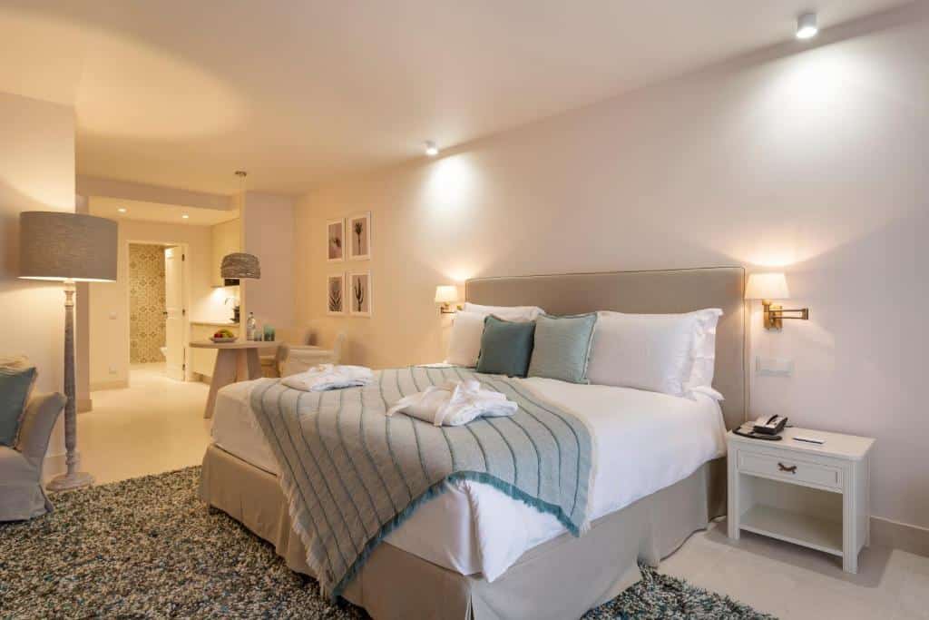 Quarto do Vila Vita Parc Resort & Spa, com cama de casal, cómoda e mesa redonda com duas cadeiras.