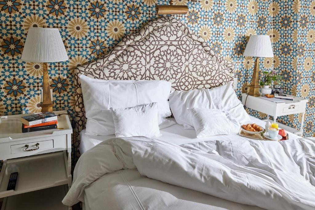 Quarto do Château Gütsch, com cama de casal, pequeno-almoço numa bandeja e papel de parede floral.
