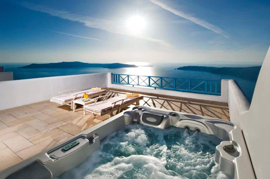 Banheira de hidromassagem ao ar livre com vista para o mar azul num hotel em Santorini, Grécia