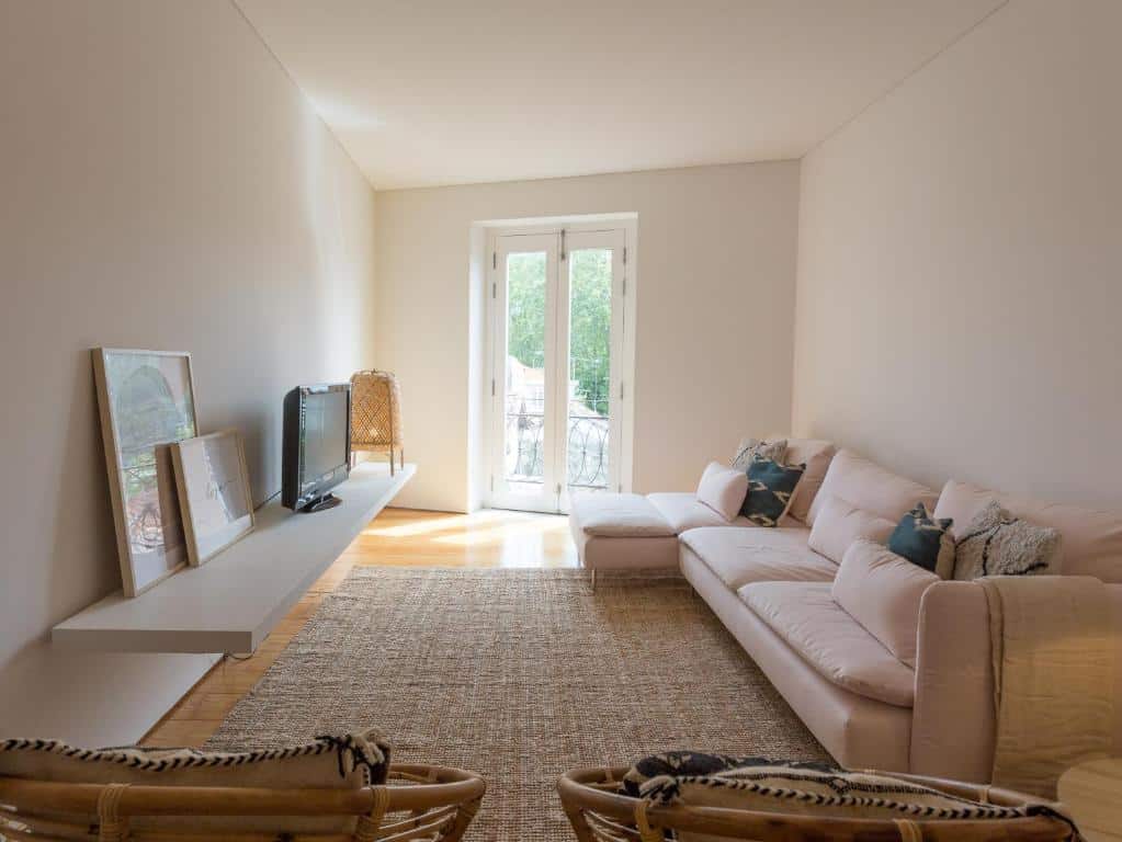 Sala de estar da Casa Castanha, com sofá à direita e um móvel com TV em frente.