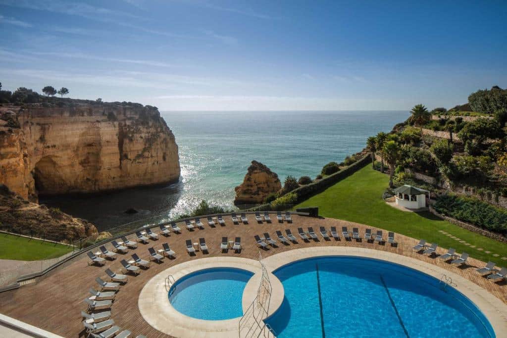 Vista aérea do Tivoli Carvoeiro, com piscina e o mar ao fundo.
