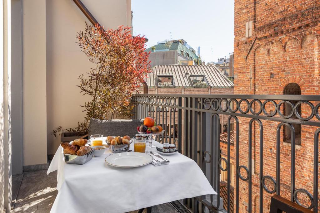 Terraço do Speronari Suites com mesa quadrada posta para o pequeno-almoço, cadeira estofada e um vaso de plantas