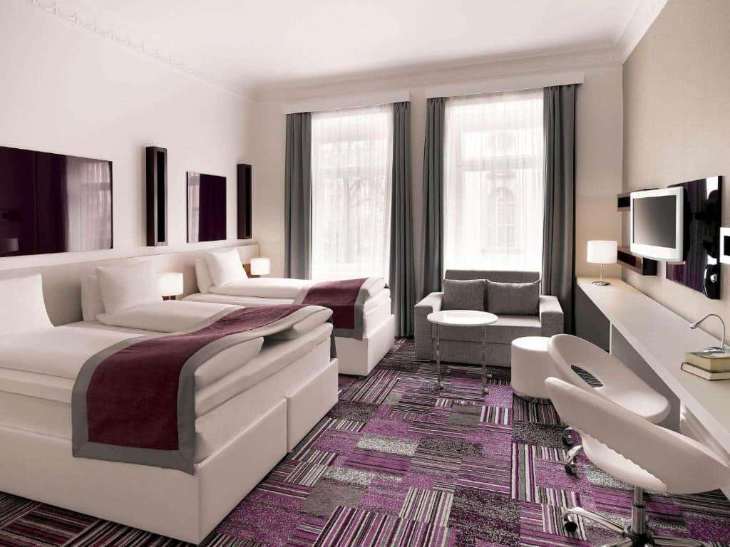 Quarto do Ibis Styles Stockholm Odenplan com cama de casal, cama de solteiro, cómoda e TV.