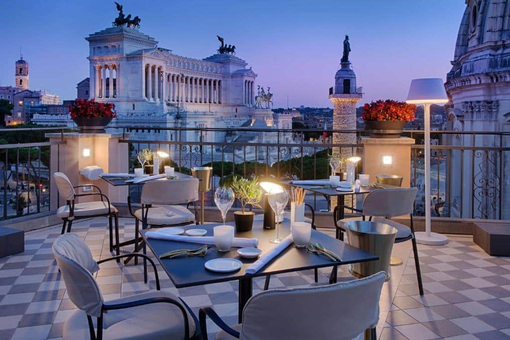 terraço do NH Collection Roma Fori Imperiali com vista para o Fórum Romano e mesas com cadeiras confortáveis