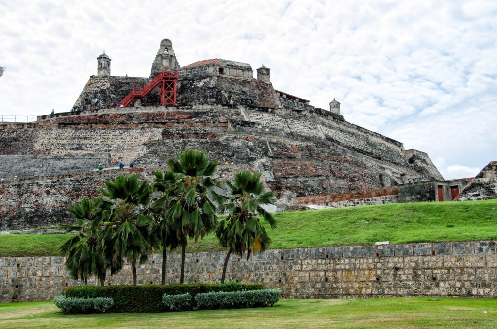 Castelo de San Felipe de Barajas, em Cartagena, uma imponente fortaleza de pedra com várias camadas de muralhas e uma escadaria vermelha.