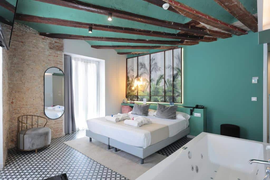 Quarto do YOU &amp; CO. Quart Boutique em estilo rústico, com parede de pedra, teto de madeira e janela com vista para uma zona verde.