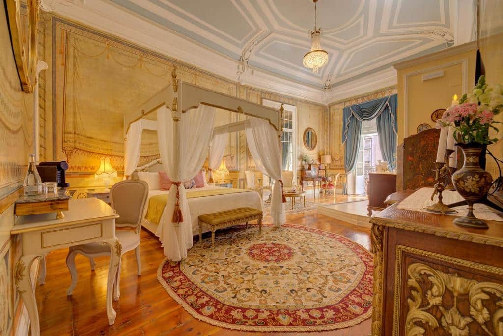Quarto de luxo com decoração inspirada na realeza portuguesa, com cama ampla, lustre, objetos de decoração dourados e bom espaço interior no Palácio das Especiarias