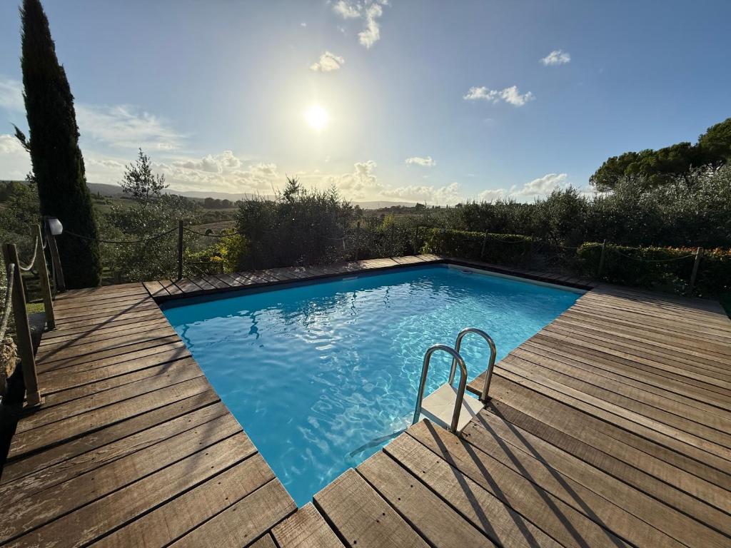 Piscina retangular de madeira com água azul clara e escada em aço inoxidável numa zona exterior soalheira