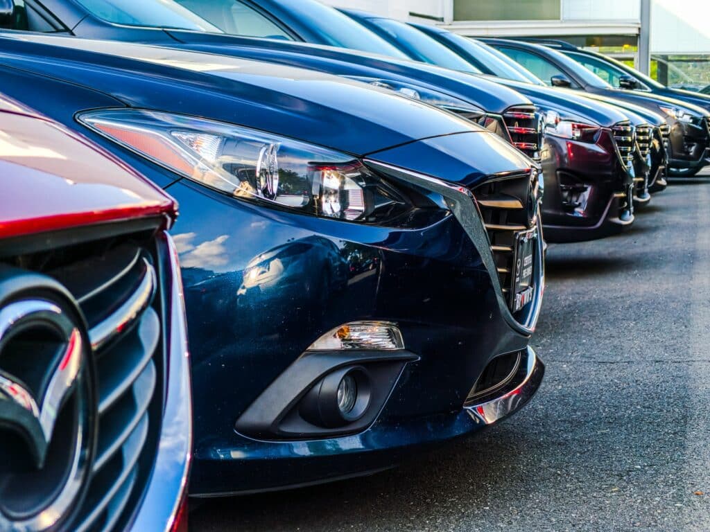Frentes de carros estacionados, lado a lado, para ilustrar artigo sobre aluguer de carro no Porto.