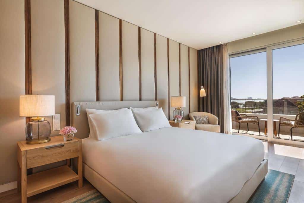 Quarto do Hyatt Regency Lisbon com varanda, cama de casal, mesas de cabeceira e poltrona estofada