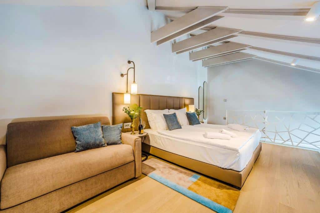 Quarto de hotel moderno com cama de casal, poltrona bege e decoração clean, na Villa Ghisi Apartments, em Kolovare