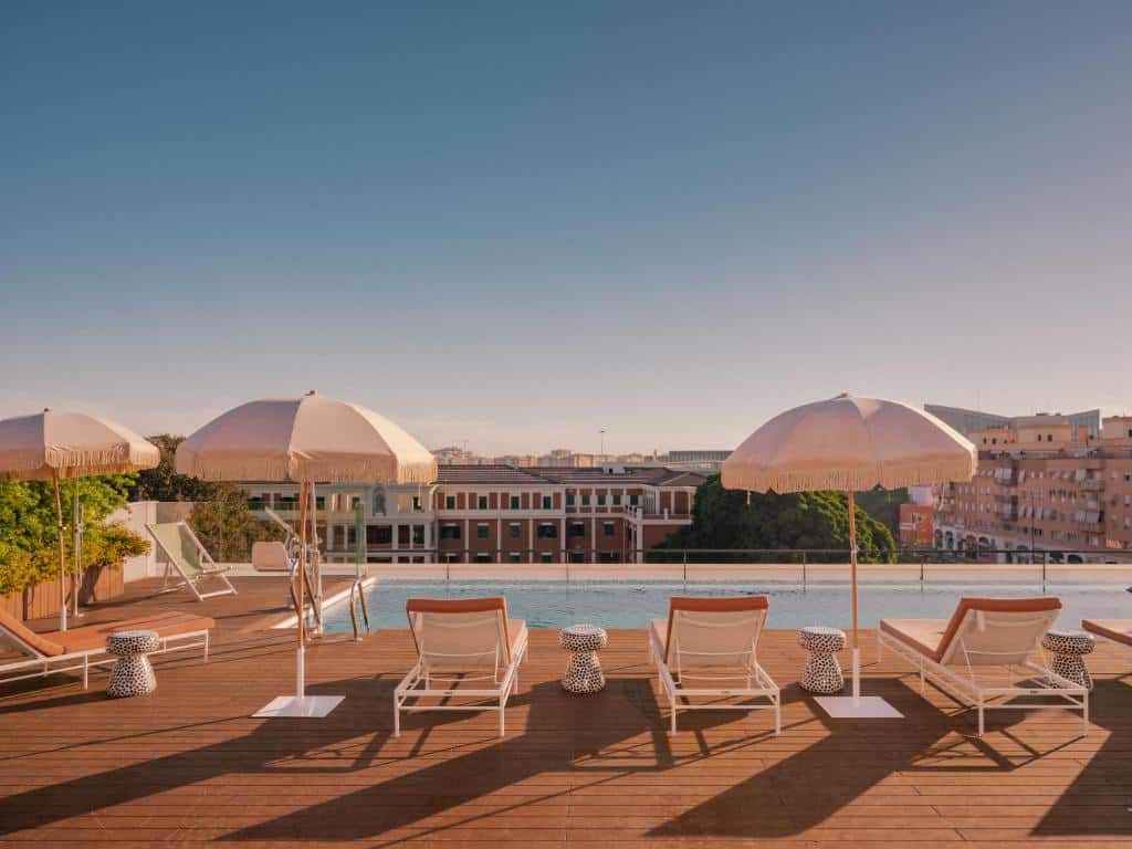 Piscina de borda infinita do Ibis Styles Sevilla City Santa Justa, com espreguiçadeiras e vista sobre a cidade.