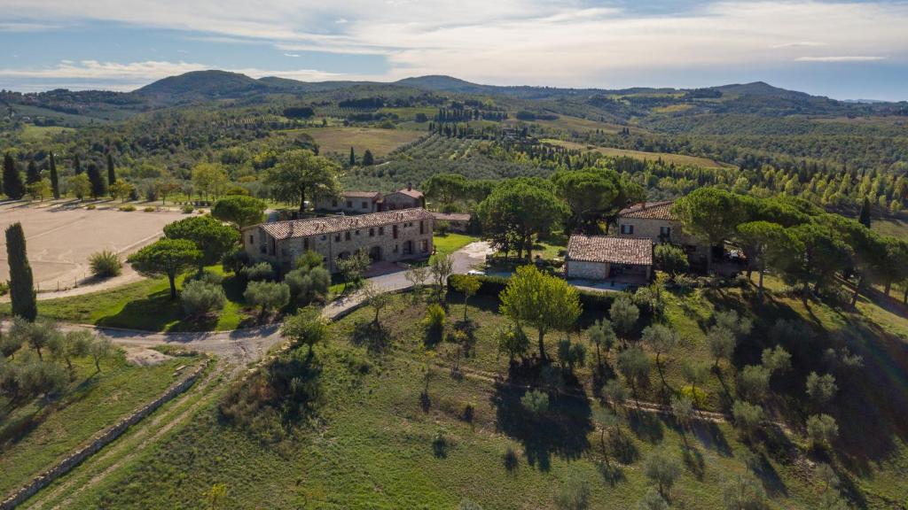 Vista aérea de um dos hotéis na Toscana, o Agriturismo Sole, com muita vegetação verde em redor e alguns edifícios de tijolo à vista
