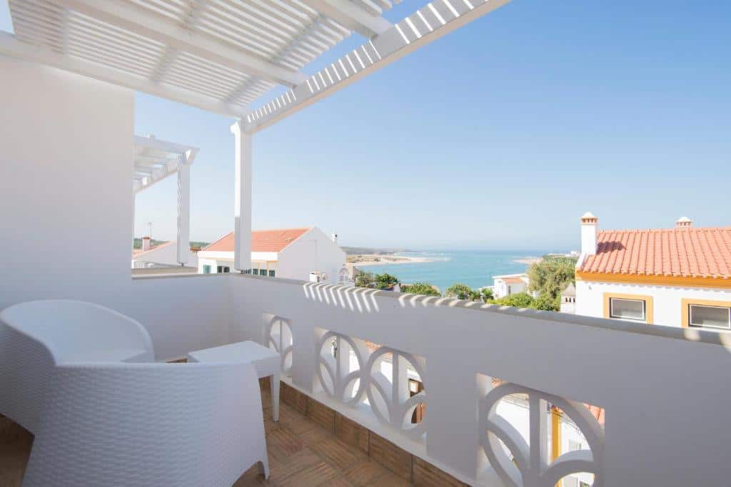 Varanda de casa branca com vista para praia e mar azul no Guarda Rios (Vila Nova de Milfontes)