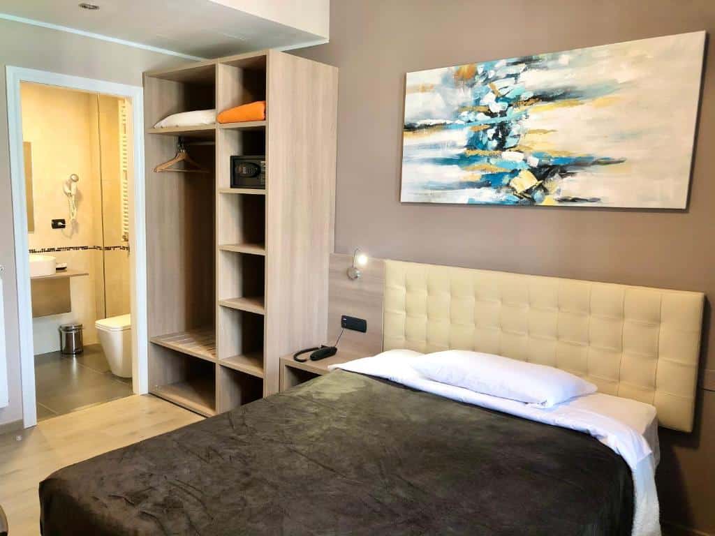 Cama de casal com roupeiro e porta da casa de banho no Hotel Folen